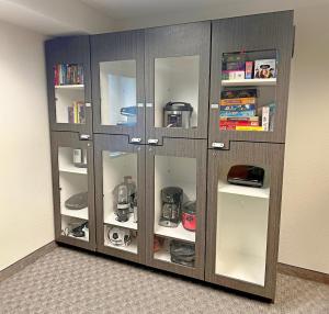 a wooden cabinet with glass doors in a room at Candlewood Suites Indianapolis Downtown Medical District, an IHG Hotel in Indianapolis