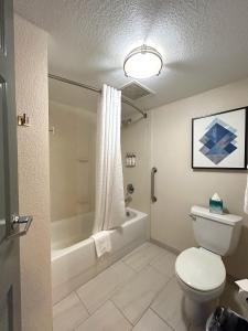 a bathroom with a toilet and a tub and a sink at Candlewood Suites Indianapolis Downtown Medical District, an IHG Hotel in Indianapolis