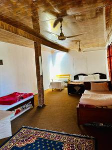 a room with two beds and a ceiling at Tourist Cottage Hunza in Hunza Valley
