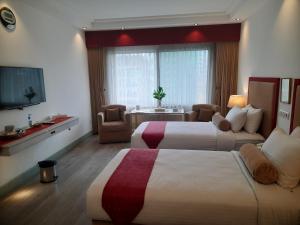 a hotel room with two beds and a television at Hotel Razmoni Isha Kha International in Dhaka