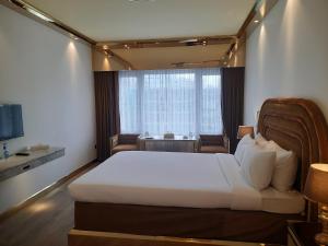 ein Hotelzimmer mit einem Bett und einem Fenster in der Unterkunft Hotel Razmoni Isha Kha International in Dhaka