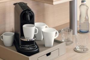 Harvey Spa Hotel في فرانتيشكوفي لاذنه: آلة لصنع القهوة السوداء على رف مع أكواب