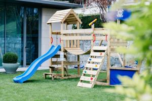 um parque infantil de madeira com um escorrega e uma escada em Hotel Angleterre & Résidence em Lausanne