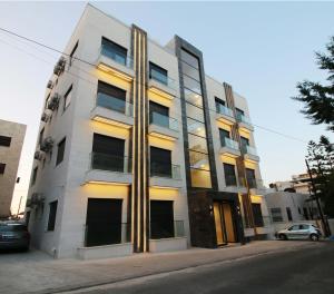 a white building with yellow lights on the side of it at KAYO Residence in Amman