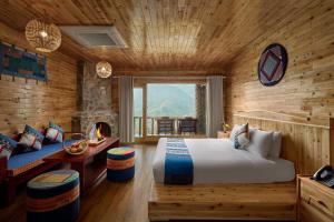 um quarto com uma cama grande e uma lareira em Laxsik Ecolodge em Sapa