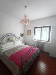 1 dormitorio con 1 cama con manta rosa en B&B le rose, en Crone