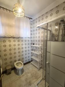 a bathroom with a toilet and a chandelier at B&B le rose in Crone