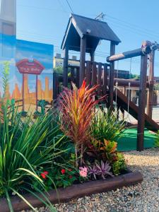 um parque com um parque infantil com plantas e um escorrega em Pousada Vila do Cowboy em Penha