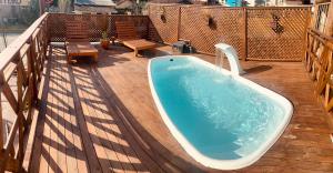 a hot tub on the deck of a balcony at Pousada Vila do Cowboy in Penha
