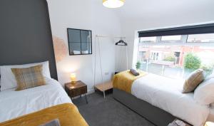 um quarto com 2 camas e uma janela em Ideal Lodgings In Audenshaw em Manchester