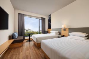 a hotel room with two beds and a large window at Fairfield by Marriott Jaipur in Jaipur