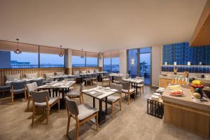 a restaurant with tables and chairs and windows at Fairfield by Marriott Jaipur in Jaipur