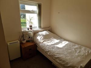 a small bedroom with a bed and a window at Harlech apartment Castle view in Harlech
