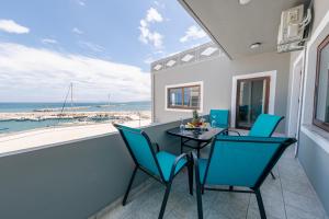 balcone con tavolo, sedie e vista sull'oceano di Luxury Sea View Apartment in Kolimvari a Kolymvari