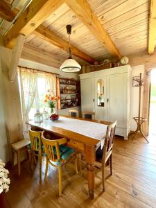 a dining room with a wooden table and chairs at POLNA CHATA in Jasionówka