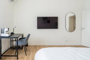 una camera da letto con scrivania, letto e specchio di Beno House Brescia a Brescia