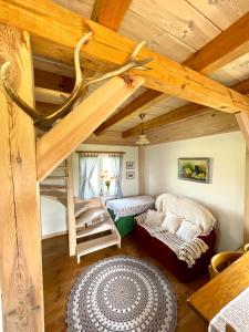 Ein Zimmer mit einem Schlafboden, auf dem ein Bett und eine Treppe stehen. in der Unterkunft POLNA CHATA in Jasionówka + 60 Fotos