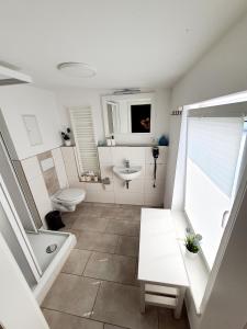 a bathroom with a toilet and a sink and a tub at Pension Apostel in Wismar +55 photos