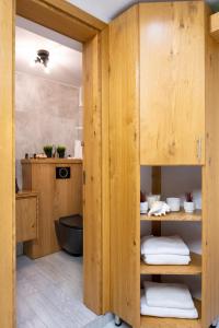 a bathroom with wooden cabinets and a black toilet at Amazing Atmosphere- Bahai Gardens Main Street in Haifa