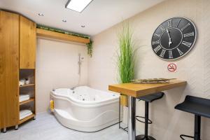 a bathroom with a tub and a clock on the wall at Amazing Atmosphere- Bahai Gardens Main Street in Haifa