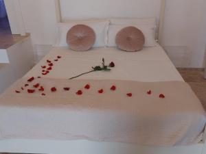 un letto con petali di rosa rosso sopra di Azalea Suite Deluxe a Sannicola