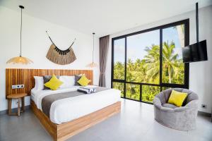 a bedroom with a large bed and a chair at Brand NEW 6BR Villa Amazing VIEWS in Ubud