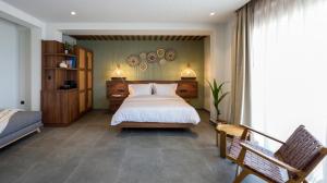 ネオス・マルマラスにあるAmyntas Seafront Hotelのベッドルーム(ベッド1台、ベンチ付)
