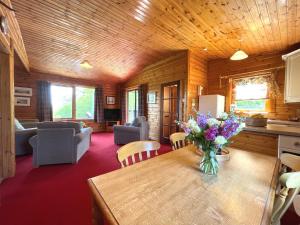 a kitchen and living room with a table with flowers on it at Pass the Keys Beautiful Golf and Beach Lodge in Stunning Location in Dalbeattie