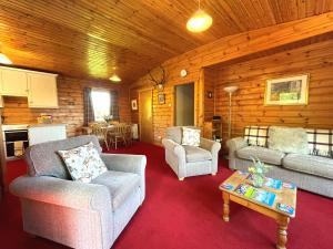 a living room with couches and a table in a cabin at Pass the Keys Beautiful Golf and Beach Lodge in Stunning Location in Dalbeattie +22 photos