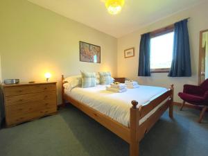 a bedroom with a bed and a dresser and a window at Pass the Keys Beautiful Golf and Beach Lodge in Stunning Location in Dalbeattie
