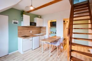 een keuken en eetkamer met een houten tafel en stoelen bij Le duplex contemporain in Pontarlier