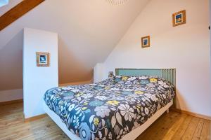 een slaapkamer met een bed met een bloemdekbed bij Le duplex contemporain in Pontarlier