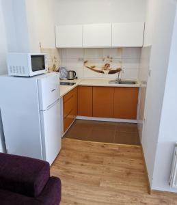 a small kitchen with a white refrigerator and a microwave at Pogodna 3B in Mielno