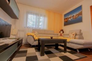 a living room with a couch and a table at Chata Biela Stopa in Vysoke Tatry - Tatranska Lomnica.