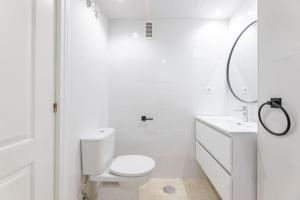 a white bathroom with a toilet and a sink at Awesome views and walk to the beach! RDR316 in Marbella