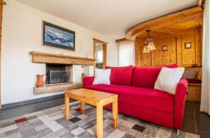 a living room with a red couch and a table at Villa Franca U01 in Arosa