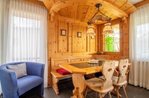 ein Esszimmer mit einem Tisch und einem blauen Stuhl in der Unterkunft Villa Franca U01 in Arosa