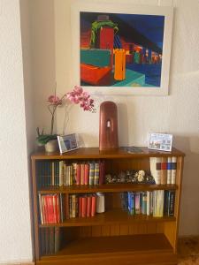 une étagère avec des livres et un vase sur elle dans l'établissement Piso en Pedregalejo a 50m de la playa., à Malaga