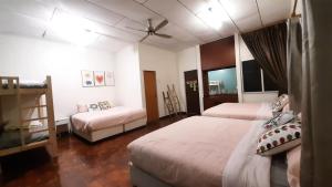 a bedroom with two beds and a ceiling fan at G Residence - Cosy 4R3B Semi-D in Brinchang Town in Brinchang