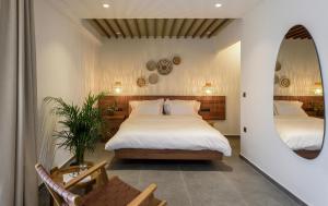 a bedroom with two beds and a mirror at Amyntas Seafront Hotel in Neos Marmaras