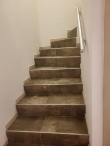 una rampa di scale con corrimano di metallo di Duplex neuf 2 chambres HUY a Huy