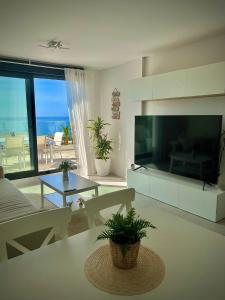 sala de estar con TV grande y sala de estar con vistas al océano. en Rincón Idilia (Málaga). en Rincón de la Victoria