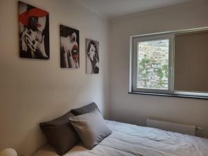 um quarto com uma cama e quadros na parede em Duplex neuf 2 chambres HUY em Huy