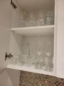 um armário cheio de copos de vinho vazios numa prateleira em Duplex neuf 2 chambres HUY em Huy