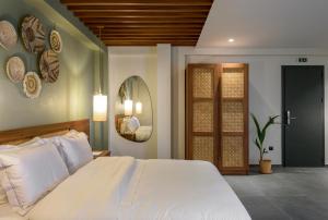 ネオス・マルマラスにあるAmyntas Seafront Hotelの大きな白いベッドと鏡のある寝室