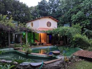 una casa con piscina di fronte a un giardino di Chalés Manhana- Água a Alto Paraíso de Goiás