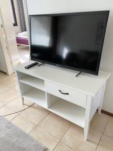 ヘルシンキにあるPIHLAJISTO 1 - Newly renovated Spacious 4-bedroom condo with patio, free parkingの白いエンターテイメントセンターの薄型テレビ