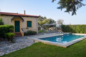 a house with a swimming pool in the yard at Aspalathos Villas in Fílippos