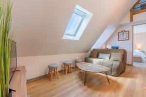 een woonkamer met een bank en een tafel bij Le Point Sublime - Netflix/Wifi Fibre/Terrasse in Banassac