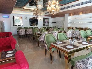 een eetkamer met tafels en groene stoelen bij Hotel ND Manor in Dehradun